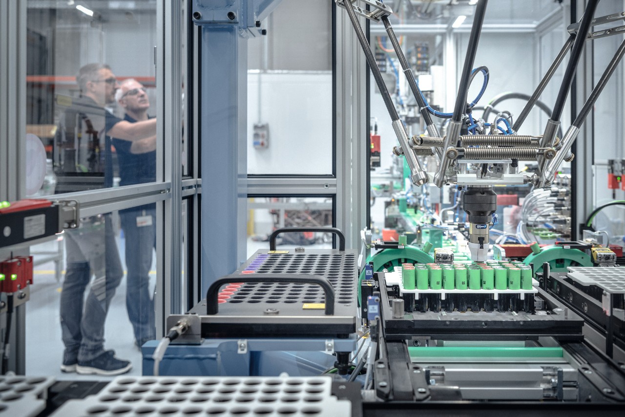 Two men in STIHL battery production surrounded by machines and robots