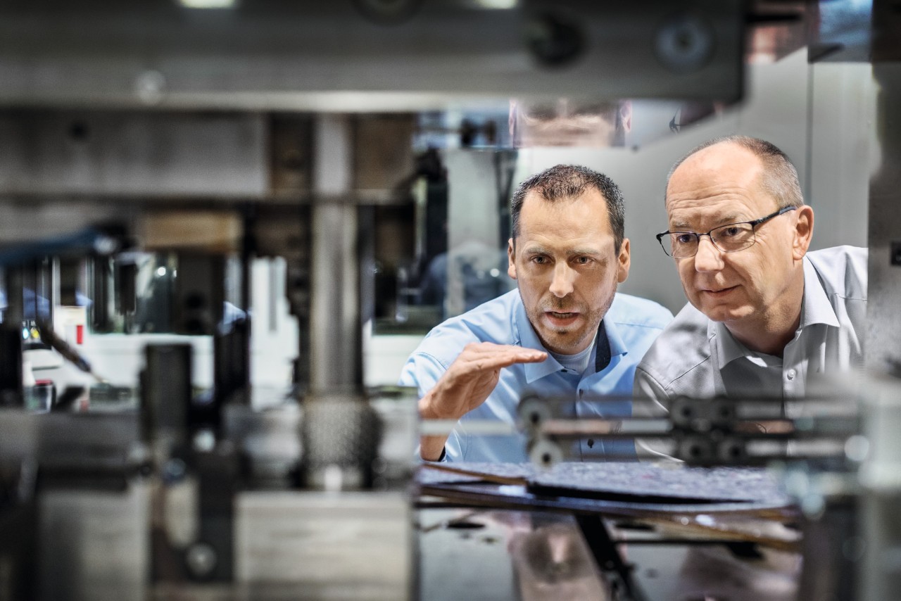 Two men looking at plant machinery in the chain factory
