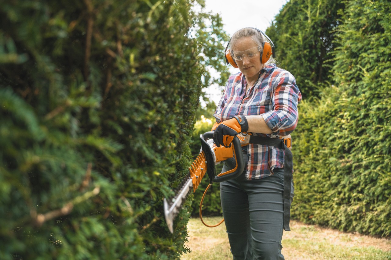 Head gardener Aldetha Raymond trims a hedge with a STIHL HSA 130 battery hedge trimmer