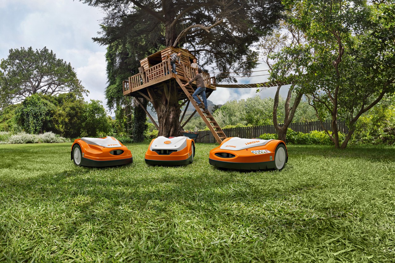The STIHL iMOW® robot mower range on a green lawn in the garden