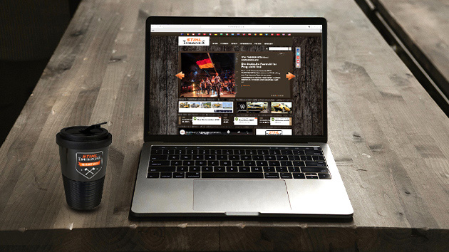 Laptop with the Timbersports website open and a Timbersports coffee mug