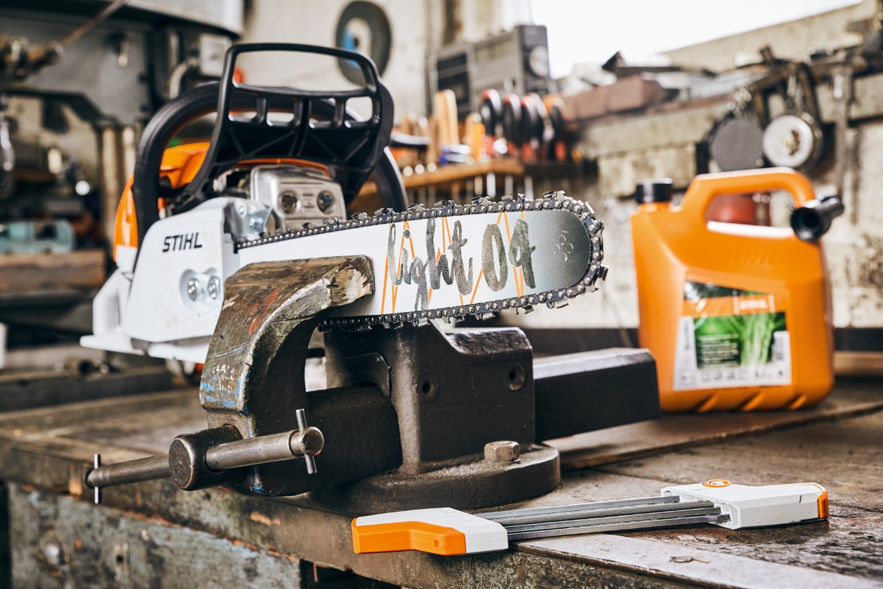 STIHL petrol chain saw MS 261 C-M with guide bar Light 04 next to STIHL fuel mixture MotoMix